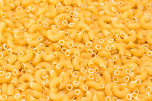 Uncooked Chifferi Rigati Pasta Background. Fat and Unhealthy Food. Classic Dry Macaroni Texture. Italian Culture and Cuisine. Raw Pasta photo