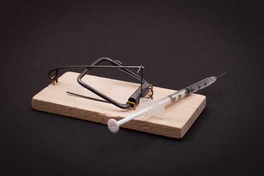 Drug Addict, Heroin Hazard or Dose Trap Concept - Disposable Insulin Syringe with Drug Dose Inside Lying in Wooden Mousetrap on Black Background photo
