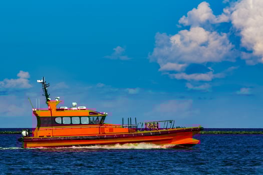 Orange pilot boat moving by the river in Europe. Rescue service photo