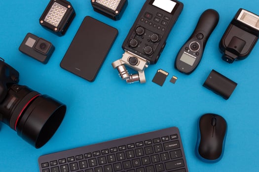 Top View of Photographer's, Videographer's or Blogger's Workplace. Digital Gadgets Lying on Blue Table - Flat Lay photo