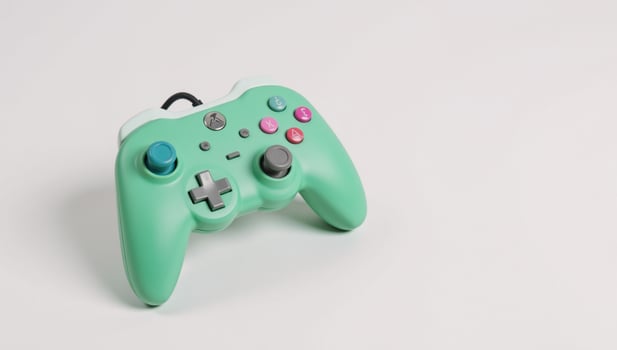 Retrostyled game controller with colorful pastel greenpink case is depicted on a clean white backdrop photo