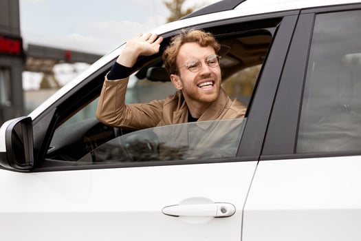 Happy businessman waving from car window photo