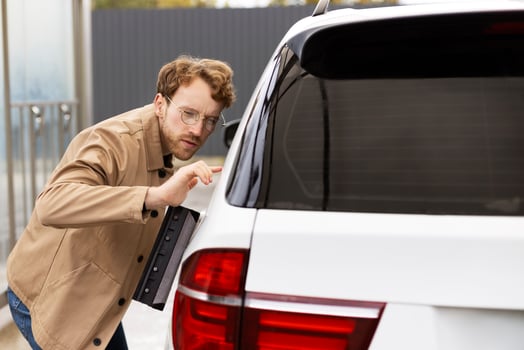 Professional car detailer examining paint for imperfections photo