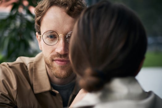 Young man looking and listening to woman in cafe photo