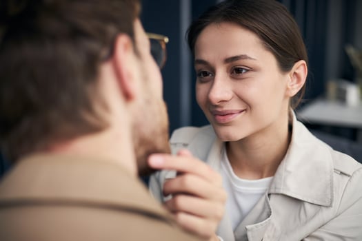 Young woman gently touching face of boyfriend looking at him with love photo