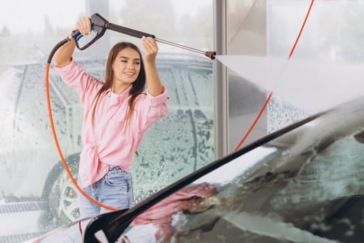 Young Woman Smiling While Washing Car at a Self-Service Station photo