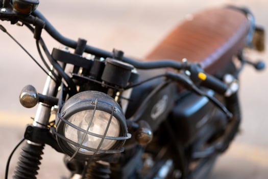 Close up of a vintage motorcycle headlight with protective grill photo