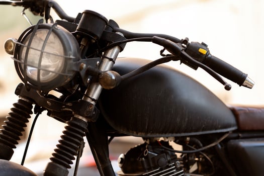 Black motorcycle parked on the street is reflecting the sun in urban scenery photo