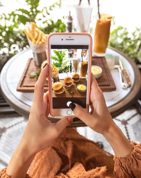 Woman taking picture of a burger menu at restaurant photo