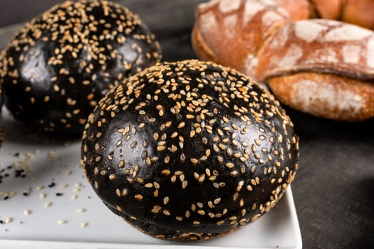 Fresh dark, black burger bread close up photo