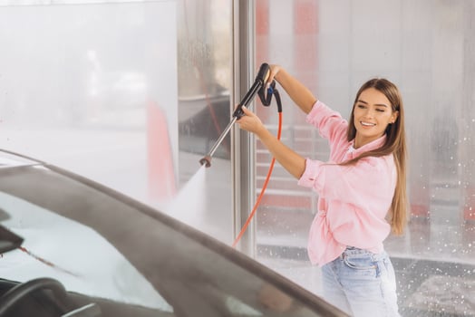 Young Woman Cleaning Car at Self-Service Car Wash photo