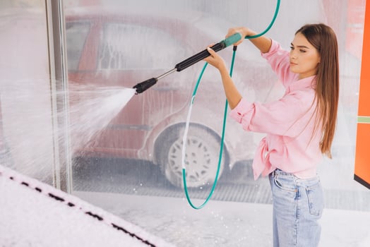 Young Woman Washing Car at Self-Service Car Wash photo