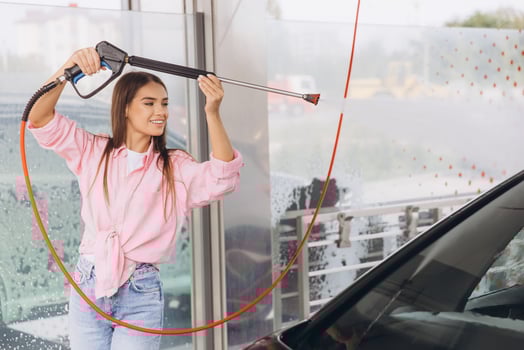 Young Woman Smiling While Washing Car at a Self-Service Station photo