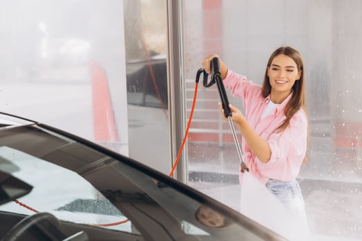 Young Woman Cleaning Car at Self-Service Car Wash photo