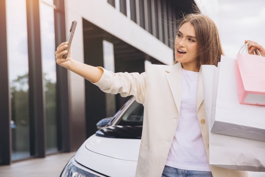 Happy Woman Taking Selfie with Shopping Bags Outdoors photo