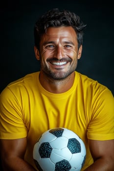 Cheerful man in yellow shirt celebrating with a soccer ball, showcasing enthusiasm and joy photo