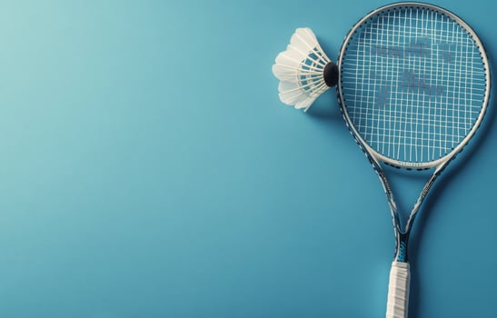 A badminton racket and shuttlecock resting on a blue background, ideal for sports enthusiasts photo