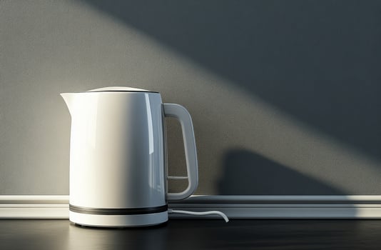 Modern white kettle on a kitchen counter against a textured gray background photo
