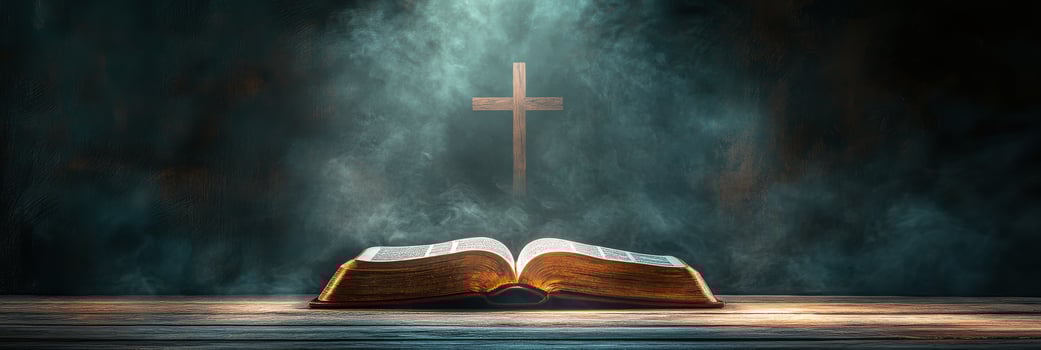 An open Bible resting on a wooden surface with a cross illuminated by soft light photo