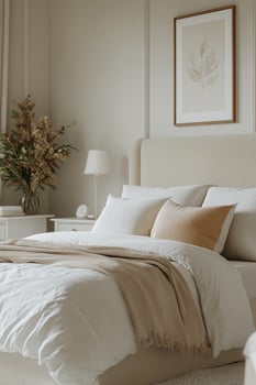 Cozy bedroom with neutral decor, soft linens, and natural light shining through the window photo