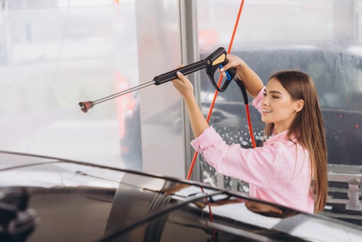 Young Woman Smiling While Washing Her Car at Self-Service photo