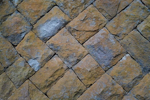 Close-up of a rustic stone wall with natural texture, ideal for backgrounds, architectural, or design elements. photo