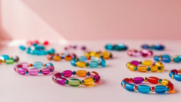 A group of colorful bracelets on a pink surface photo