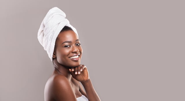 Beautiful african american woman after bath, smiling with white towel on head, empty space photo