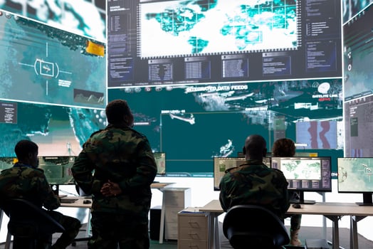 Woman recruit overseeing information gathering activity in command post, military headquarters personnel use CCTV radar surveillance for reconnaissance on a big screen. Secret service division. photo
