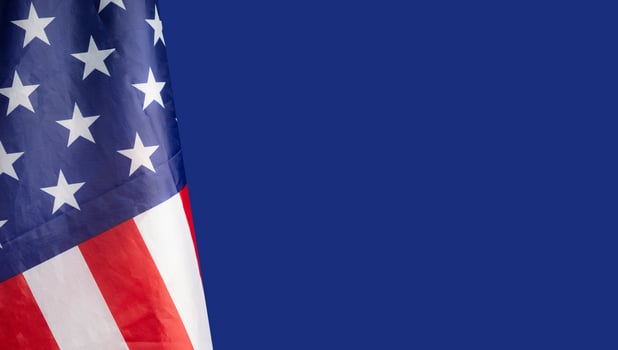 Close-up of the American flag is on the left side on a blue background photo