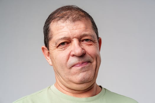 Middle-aged man with a thoughtful expression against a plain background photo