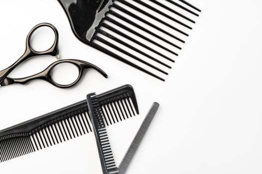 Black hairdressing tools and various hairbrushes on white background photo