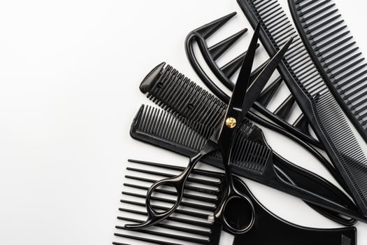 Black hairdressing tools and various hairbrushes on white background photo