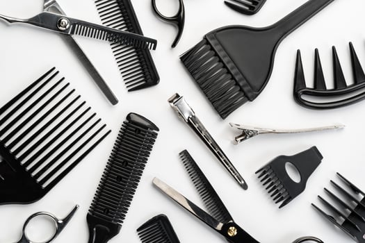 Black hairdressing tools and various hairbrushes on white background photo