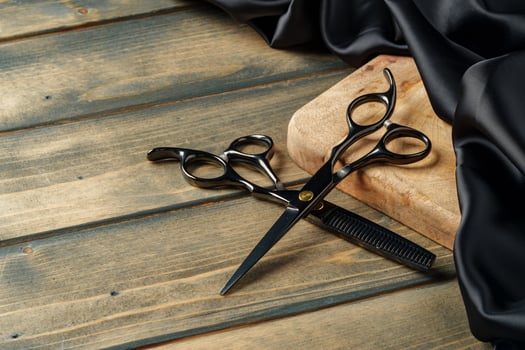 Hairdressing professional scissors on wooden background close up photo