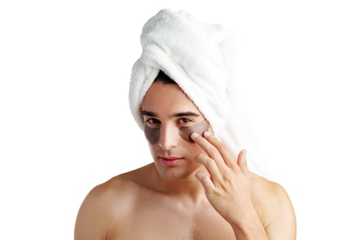 Portrait of attractive young male model with eye patches on white background photo