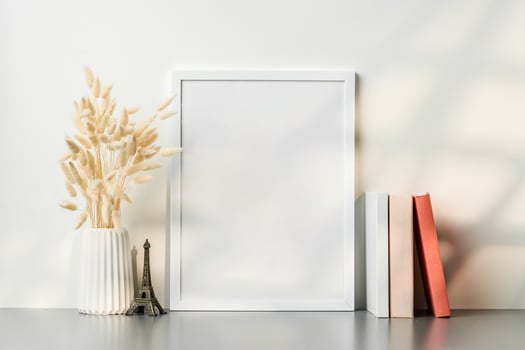 Blank picture frame and dried flower in a vase on white background photo