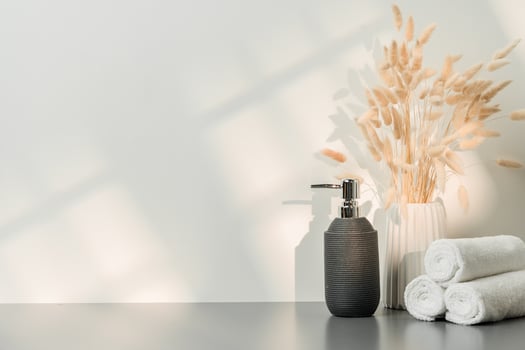 Soap dispenser and spa towels on white background in shadow photo