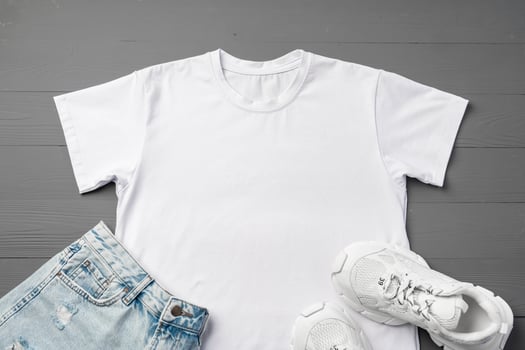 T-shirt, jeans and white sneakers on gray background top view photo