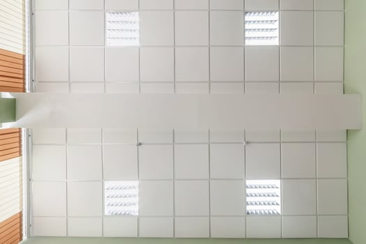 cassette stretched or suspended ceiling with square halogen spots lamps and drywall construction in empty room in house or office. Looking up view photo