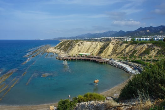 Peaceful Coastal View of a Secluded Bay With Rocky Shores and Gentle Waves in a Sunny Afternoon Setting photo