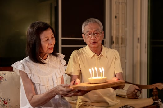 Senior asian couple is happily celebrating birthday together at home for love, relationship, bonding, longevity and marriage concept photo