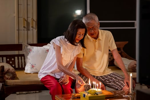 Senior asian couple is happily celebrating birthday together at home for love, relationship, bonding, longevity and marriage concept photo
