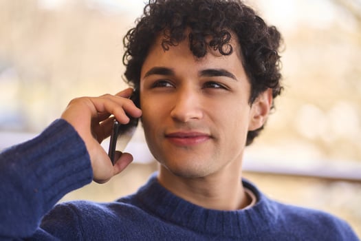 Young man using smartphone and smiling photo