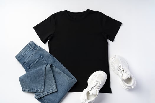 T-shirt, jeans and white sneakers on gray background top view photo