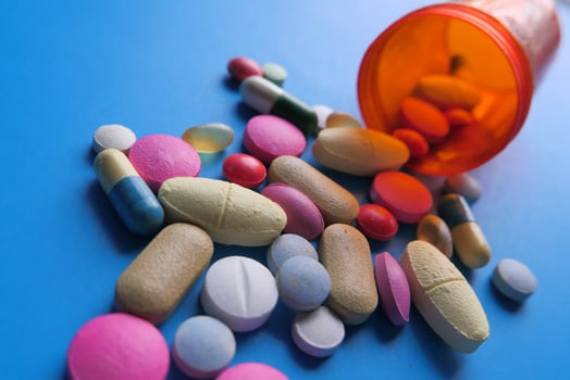 A Variety of Various Pills and Capsules Spilling Out from a Prescription Medication Bottle photo