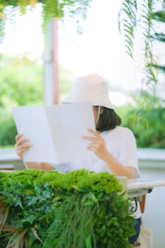 Close up and selective focus hands of teenage girl holding and reading book or magazine and sitting in chair at garden of home. photo