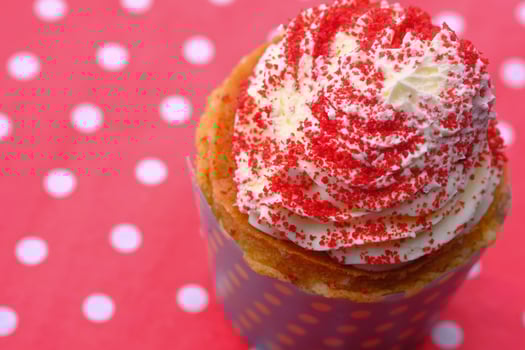 Enjoy a delightful cupcake topped with whipped cream and bright red sprinkles for any occasion photo