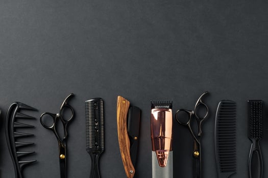 An Assortment of Professional Hairdressing Tools Laid Out on a Dark Surface photo