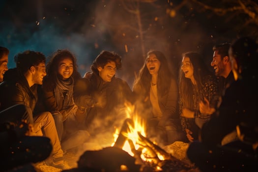 A group of young people sitting around a campfire photo